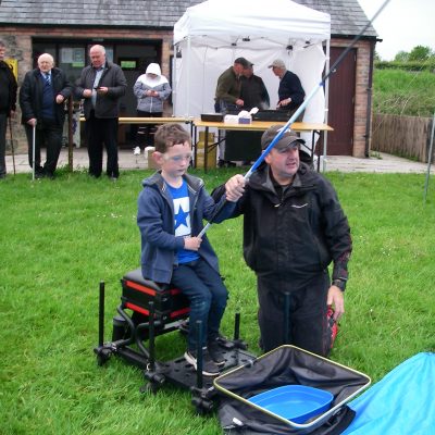 BAC - Juvenile and Junior Prize Distribution at Corbet Lough on 30 May 2019 - Philip Jackson tuitors a young angler with his fishing game